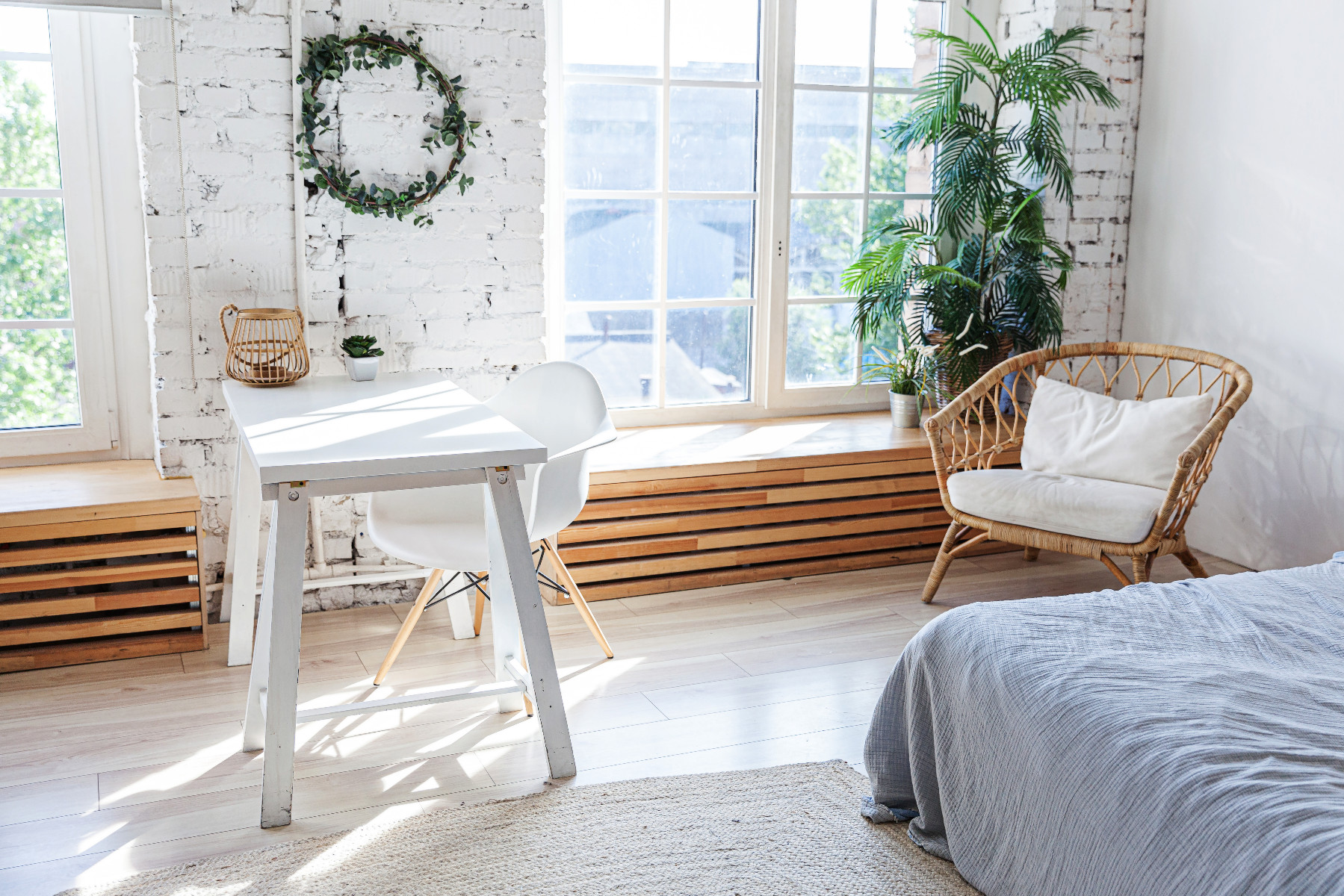 Stylish loft modern home office interior. Spacious design apartment with light walls large windows and writing desk. Clean modern decoration with elegant furniture in minimalist Scandinavian style.